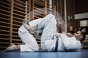 Two young males practicing judo together.