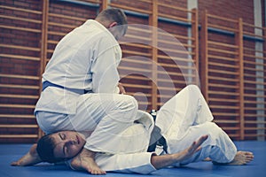 Two young males practicing judo together.