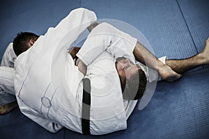 Two young males practicing judo together.