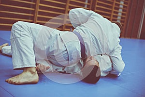 Two young males practicing judo together.