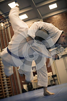 Two young males practicing judo together.