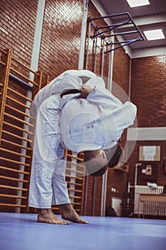 Two young males practicing judo together.