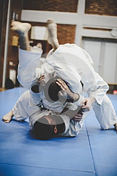 Two young males practicing judo together.