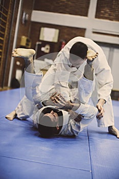 Two young males practicing judo together.