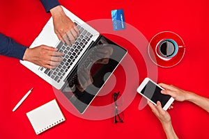 Two young man using laptop and a smartphone. Focus on the hand