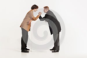 Two young men in 70s, 80s fashion style clothes wrestle isolated on white background. Vintage, retro style concept