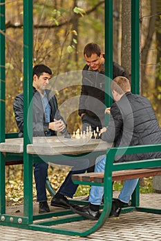 Two young men in black jackets playing chess,