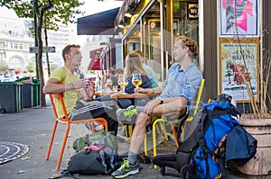 Two young men enjoying glass of beer in cafe in Paris