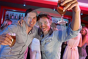 Two Young Men Having Fun In Busy Bar