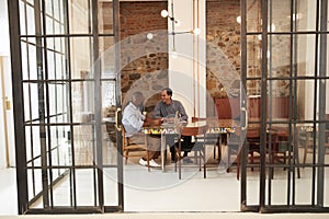 Two young men at a meeting in a boardroom