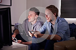 Two Young Men Playing Video Game At Home