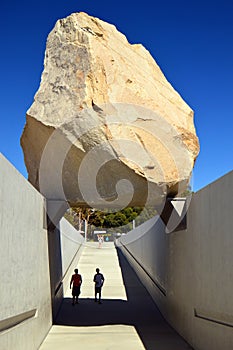 Two young men stand under Levitated Mass