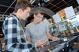 Two young men stood behind decks photo