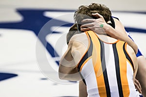 Two young men tying up while wrestling.