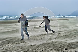 Two young men on a windy beach