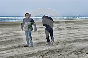 Two young men on a windy beach