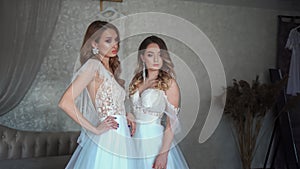 Two young models posing in front of the photographer in a wedding dress.