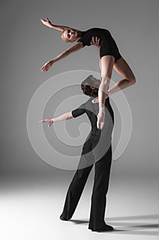 Two young modern ballet dancers on gray studio