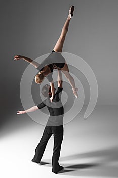 Two young modern ballet dancers on gray studio