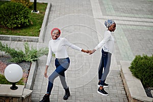 Two young modern fashionable, attractive, tall and slim african muslim womans in hijab or turban head scarf posed together