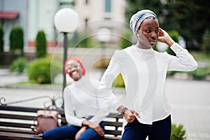 Two young modern fashionable, attractive, tall and slim african muslim womans in hijab or turban head scarf posed together