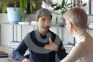 Two young multiracial employees discussing working issues.