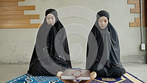 Two young Muslim women are performing prayers. Islamic religion,part 1