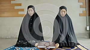 Two young Muslim women are performing prayers. Islamic religion,part 2