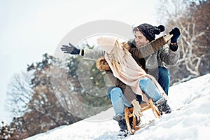 Two young people sliding on a sled