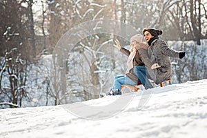 Two young people sliding on a sled