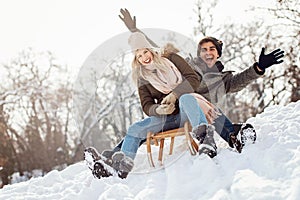 Two young people sliding on a sled