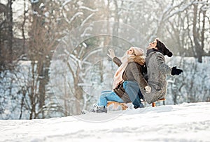 Two young people sliding on a sled