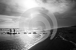 Two young people walk along a jetty out to sea