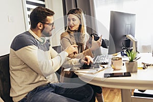 Two young photographers working in office