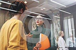 Two young positive businesswoman meeting in openspace office