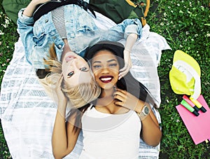 Two young pretty teenager girls best friends laying on grass mak