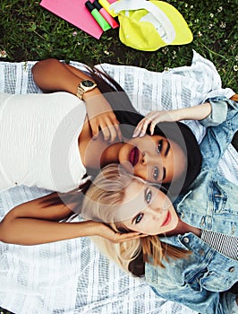 Two young pretty teenager girls best friends laying on grass making selfie photo having fun, lifestyle happy people