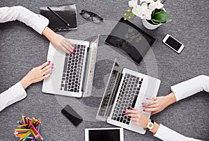 Two young professionals working with computer, view from above