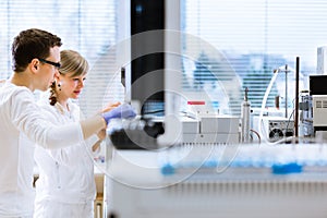 Two young researchers carrying out experiments in a lab