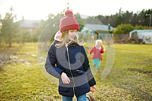 Two young sisters having fun together on beautiful spring day. Active family leisure with kids. Family fun outdoors