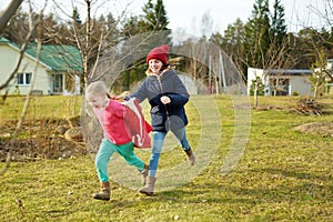 Two young sisters having fun together on beautiful spring day. Active family leisure with kids. Family fun outdoors