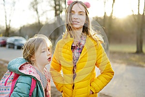 Two young sisters having fun together on beautiful spring day. Active family leisure with kids. Family fun outdoors