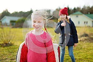 Two young sisters having fun together on beautiful spring day. Active family leisure with kids. Family fun outdoors