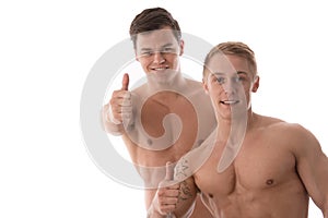 Two young smiling bodybuilder gesturing thumbs up sign
