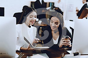 Two Young Smiling Women Working in Call Center. Manager with Computer. Girl on Workplace. Consultant with Microphone. Customer