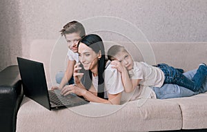 Two young sons interfere with working on a laptop at home during self-isolation. home working environment with children