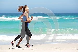 Two young sporty women running on the beach