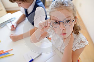 Two young student of an elementary school sitting at a desk.