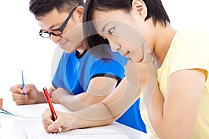 Two young students exams together in classroom photo