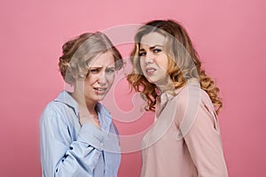 Two young stylish girls are upset and shocked by the disgusting incident. On their faces an expression of extreme disgus